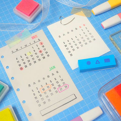 Calendars and stationery items on a blue surface