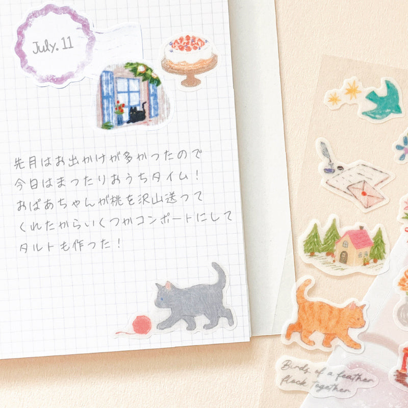 Notebook with cat illustrations and stickers on a wooden surface