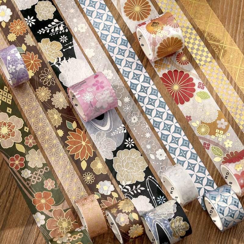 Collection of decorative washi tape rolls with various patterns on a wooden surface.