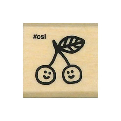Rubber stamp with smiley face cherries and '#csi' text on a wooden block.