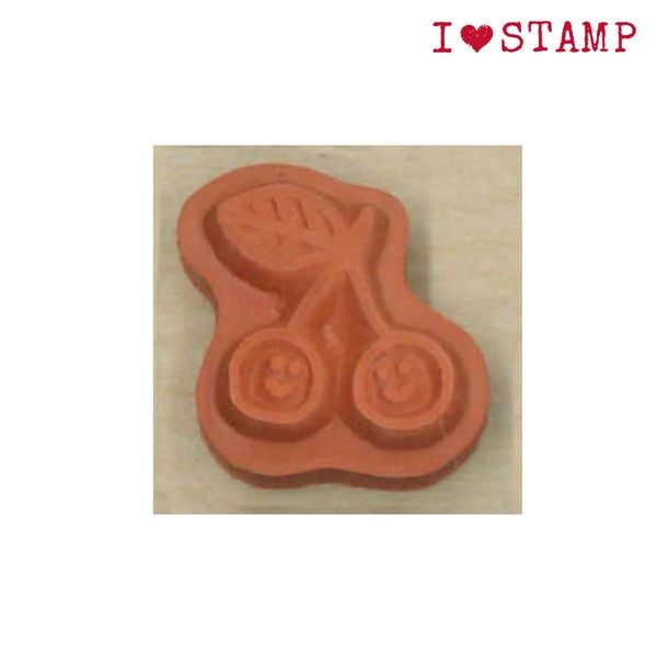 Red rubber stamp with scissors design on a wooden block, branded &