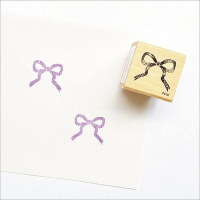 Rubber stamp with bow design on a white background
