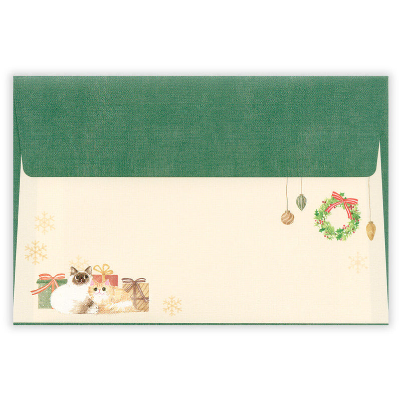 Green envelope with a cat and Christmas decorations on a white background
