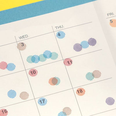 Calendar with colorful dot stickers on a blue and yellow background