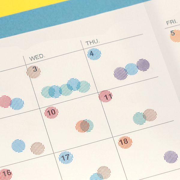Calendar with colorful dot stickers on a blue and yellow background