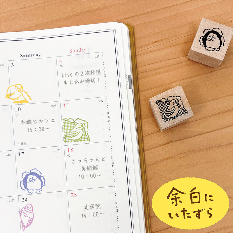Rubber stamps with cartoon designs on a wooden surface next to a calendar.