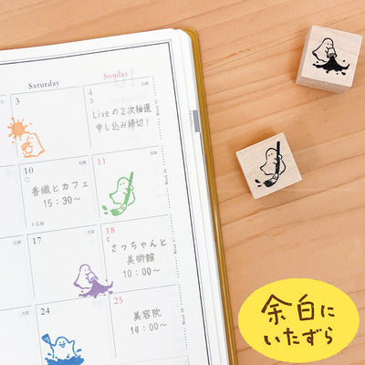 Calendar with cute character stamps on a wooden surface