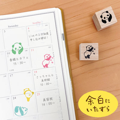 Panda-themed rubber stamps on a wooden surface next to a calendar.