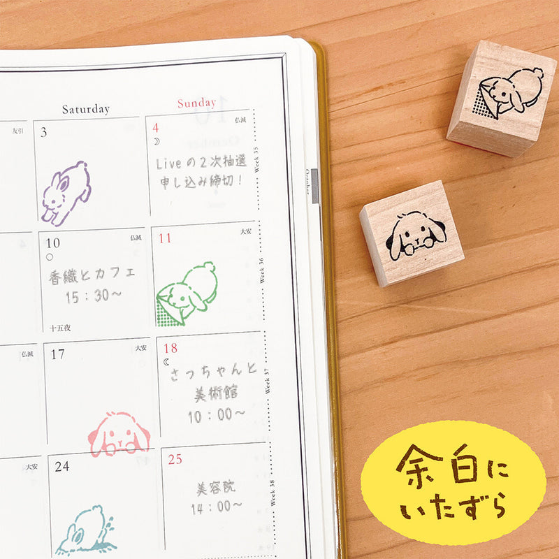 Calendar with hand-drawn stamps of a rabbit on a wooden surface