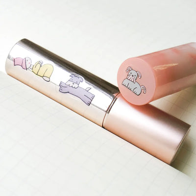 Lip gloss with cartoon character designs on a light background