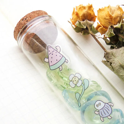 Glass bottle with cork lid containing cartoon characters on a white background