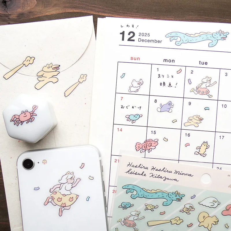 Calendar with cartoon illustrations of animals and a phone case with similar designs on a wooden surface.