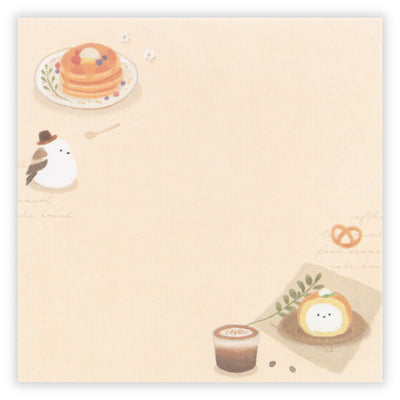 Illustrated notepad with food-themed design on a beige background
