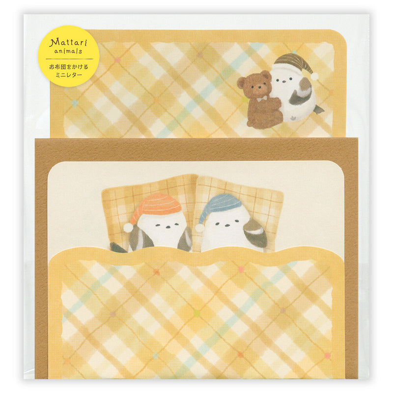 Set of stationery items with cartoon characters under a blanket on a white background