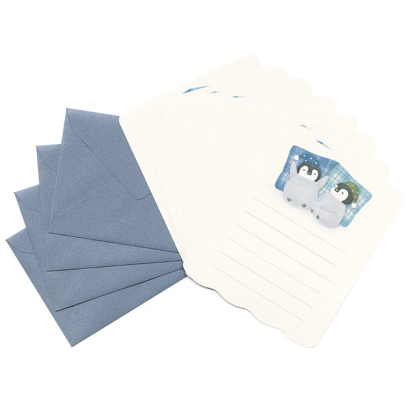 Set of blue envelopes and a white notepad with penguin design on a white background