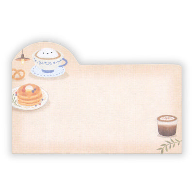 Note pad with illustrations of a cup of coffee, pancakes, and pretzels on a beige background