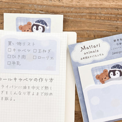 Notebook with stickers featuring cartoon animals on a wooden surface