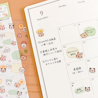Calendar with cute animal stickers on a wooden surface