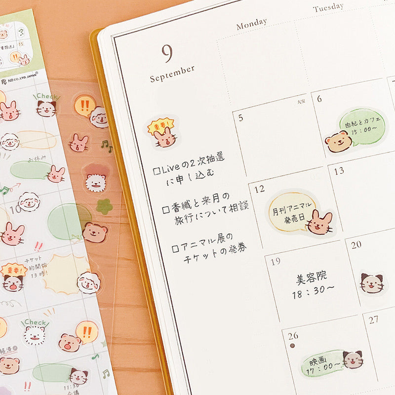 Calendar with cute animal stickers on a wooden surface