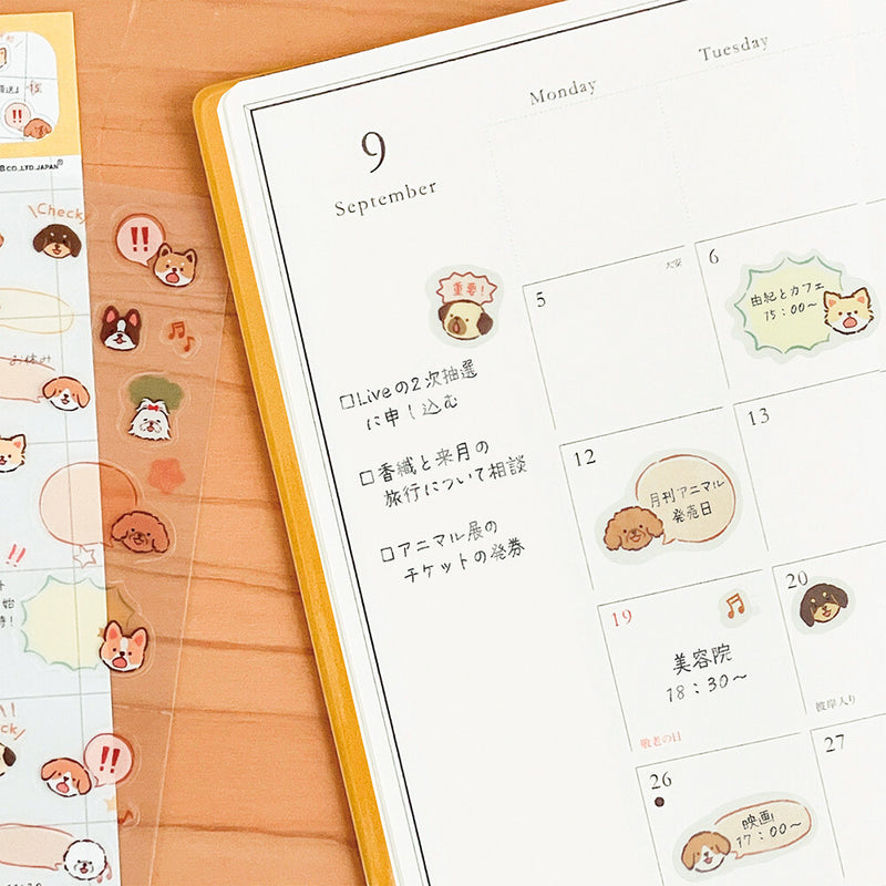 Calendar with cute animal stickers on a wooden surface