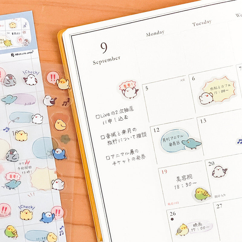 Calendar with cute animal stickers on a wooden surface