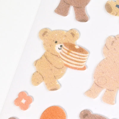 Sticker of a bear holding a stack of pancakes on a white background