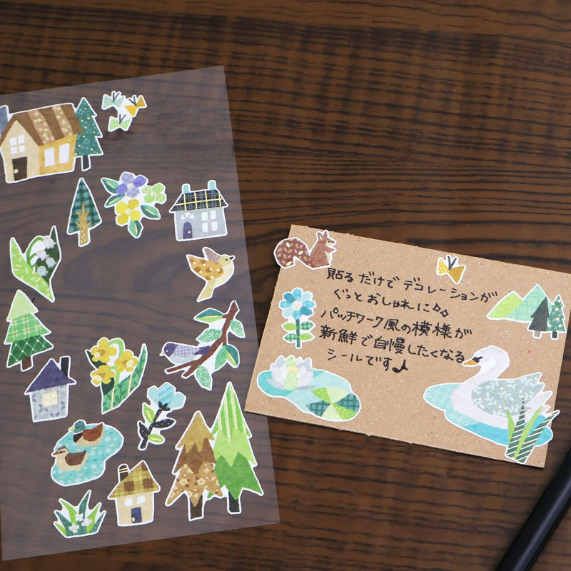 Set of decorative stickers featuring houses, trees, and birds on a wooden surface.