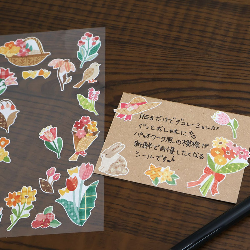 Set of decorative stickers with flowers, birds, and rabbits on a wooden surface.