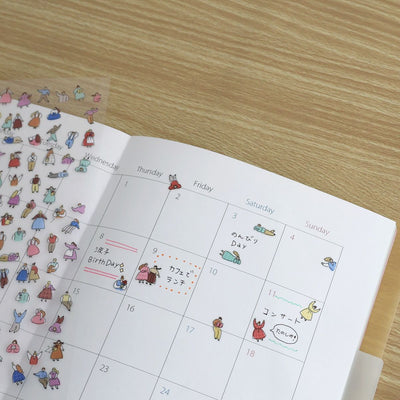 Calendar with cartoon illustrations on a wooden surface