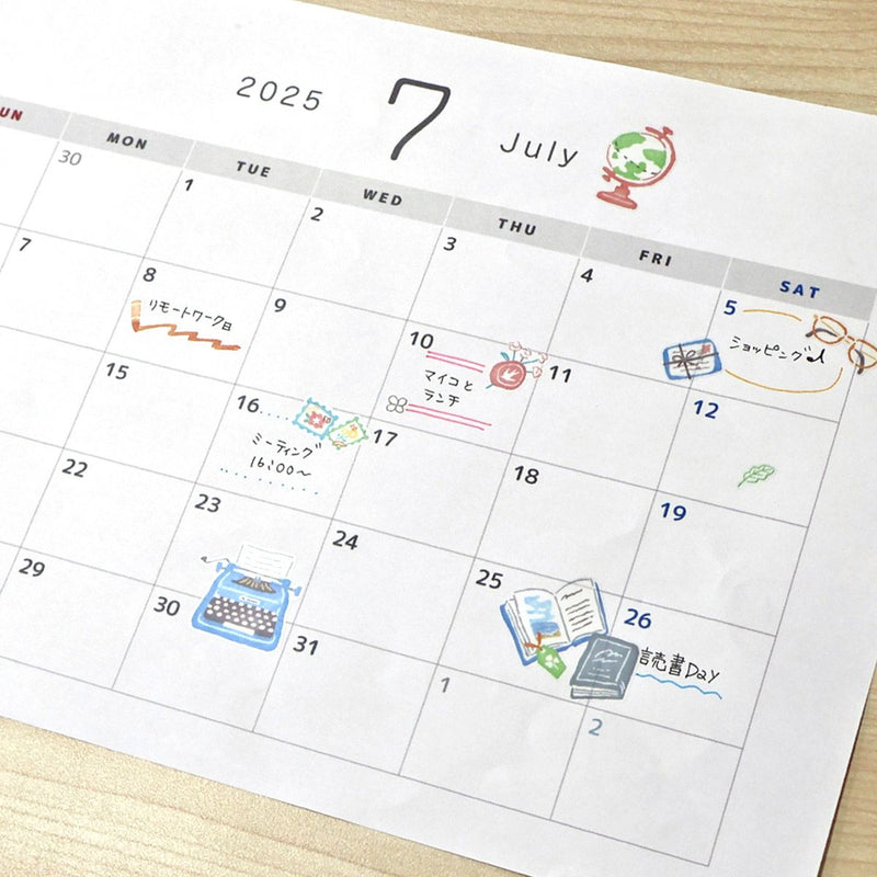 Calendar for July 2025 with various icons and notes on a wooden surface