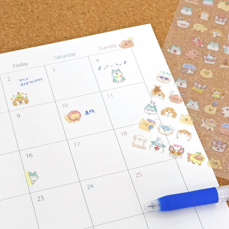 Calendar with cute animal stickers and a pen on a cork background