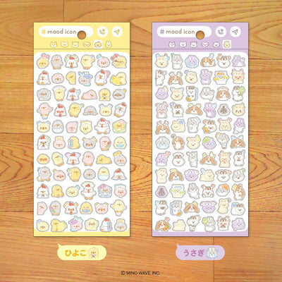 Two sheets of cute animal-themed stickers on a wooden surface