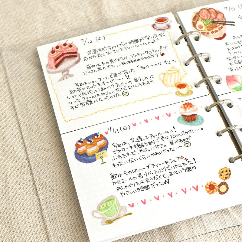 Notebook with illustrated food pages and text on a beige surface