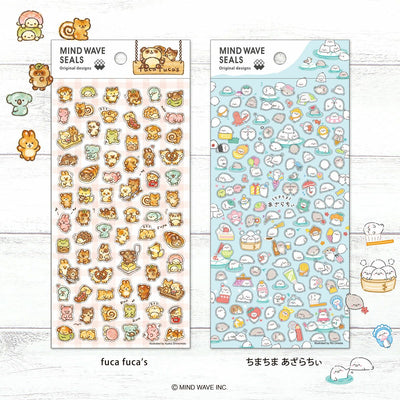 Two sheets of 'MIND WAVE SEALS' stickers with various designs on a wooden surface.