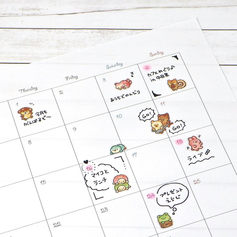 Calendar with cute animal illustrations and text on a white wooden surface