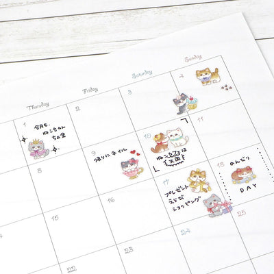 Calendar with cute cat illustrations on a wooden surface