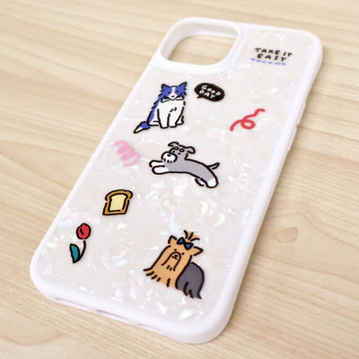 Phone case with cartoon dog illustrations on a wooden surface