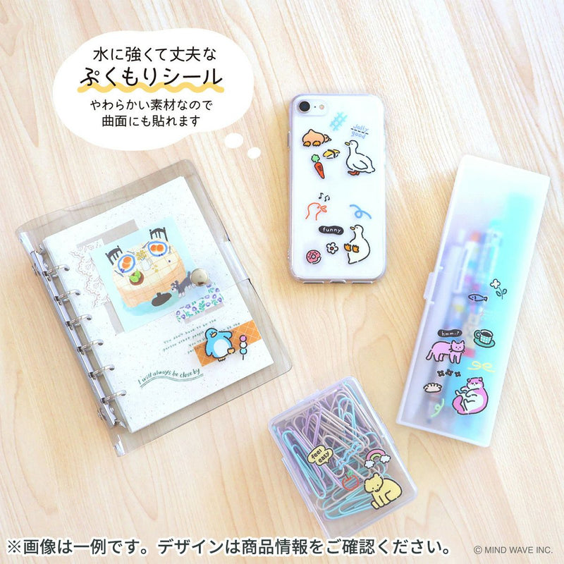 Stationery items including a phone case, notebook, and clips on a wooden surface.