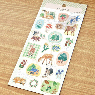 Sheet of nature-themed stickers with animals and plants on a wooden surface