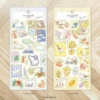 Two packages of decorative stickers with animal illustrations on a wooden surface.