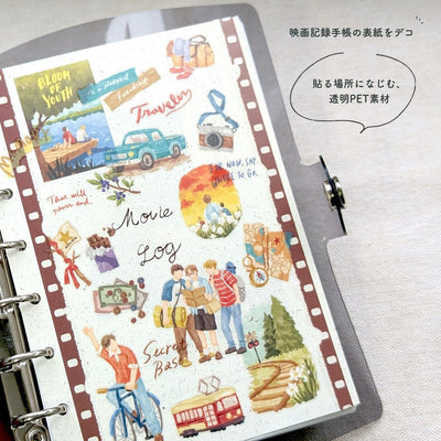 Sticker sheet with travel-themed designs on a ring-bound notebook.