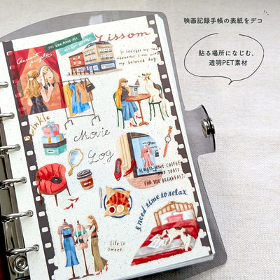 Planner with decorative stickers featuring various scenes and text on a white background.