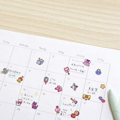 Calendar with cartoon character stickers on a wooden surface