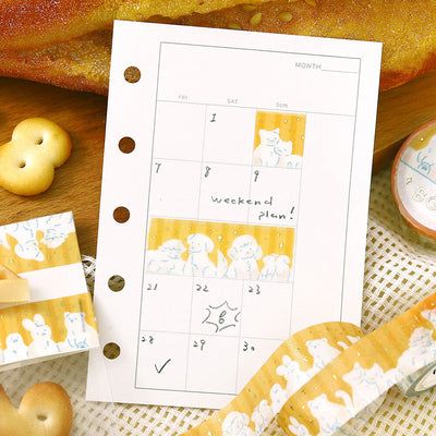 Calendar planner sheet with cartoon designs on a wooden surface with cookies.