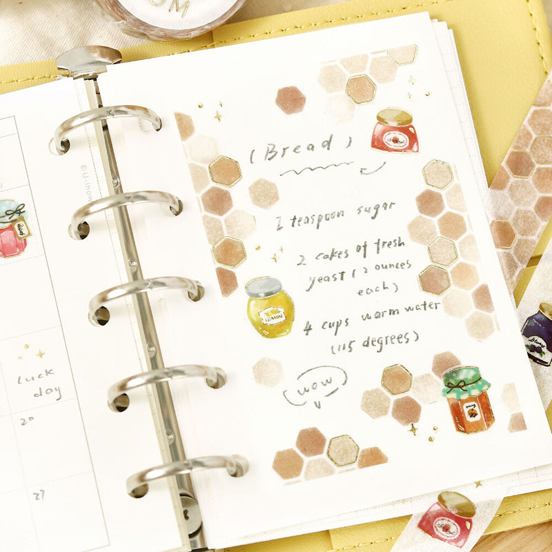 Planner with a recipe card featuring honey and bread illustrations on a yellow background