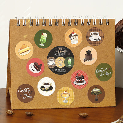 Calendar with coffee-themed stickers on a wooden surface
