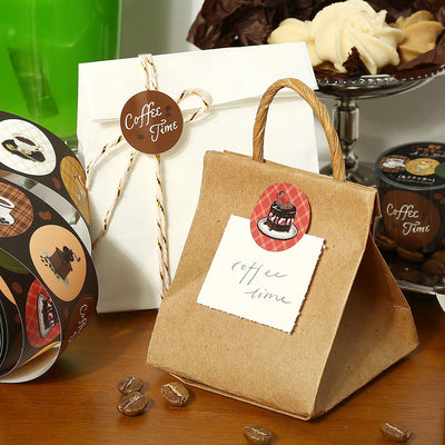 Kraft paper gift bag with 'Coffee Time' tag and coffee-themed decorations on a wooden surface.