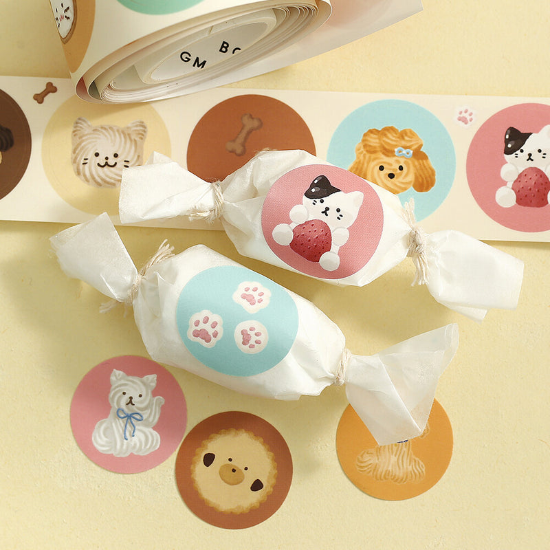 Candies wrapped in white paper with cute animal stickers on a yellow background