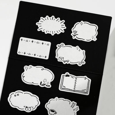 Set of black and white decorative stickers on a black card