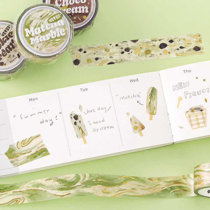 Ice cream-themed stationery items including washi tape and a planner on a green surface.
